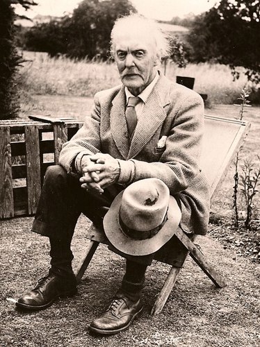 Artist Fred Appleyard sitting in a chair with a Panama hat